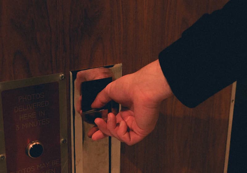 Person turning a door handle to unlock a door